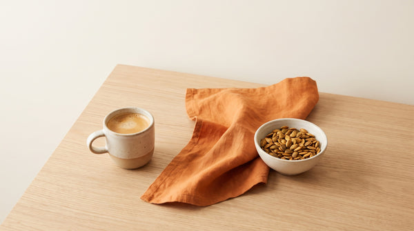 Tazzina di caffe' e semi di zucca distanziati sul tavolo