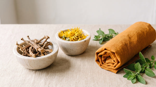 Radici di artiglio del diavolo e fiori di arnica in ciotole di pietra