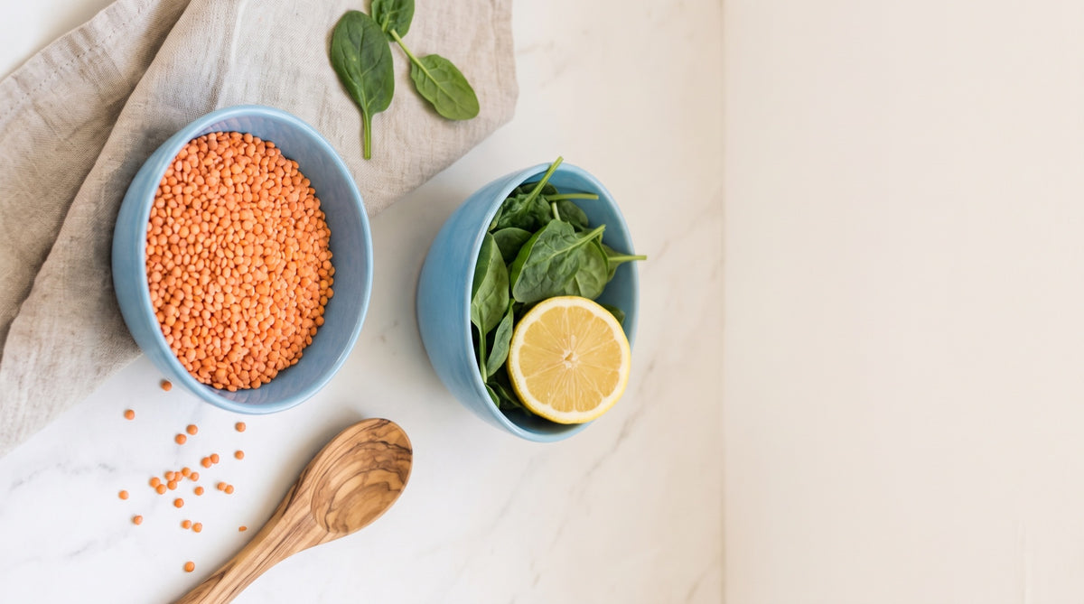 Lenticchie, spinaci e limone in ciotole di ceramica su marmo chiaro