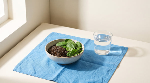 Lenticchie e spinaci con un bicchiere d'acqua alla luce del sole