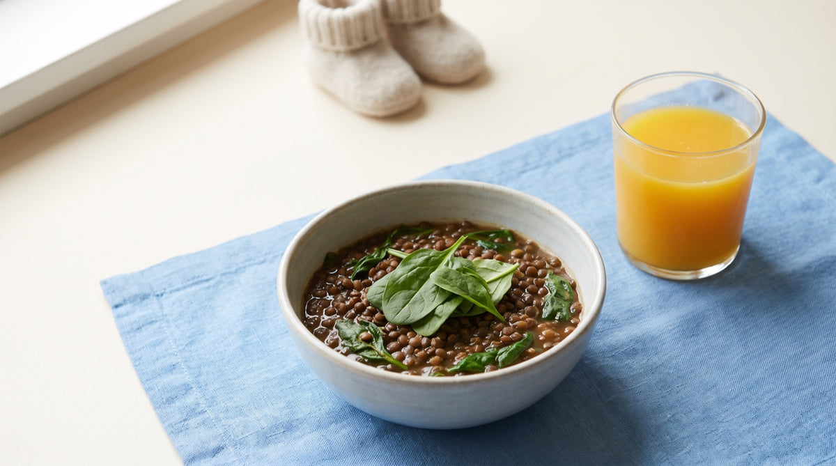 Lenticchie, spinaci e spremuta con scarpine di lana sfocate
