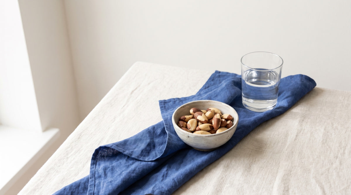 Noci del Brasile in ciotolina di ceramica con bicchiere d'acqua