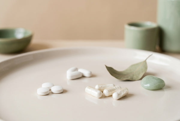 Forme di magnesio a confronto: compresse e capsule su un piatto chiaro